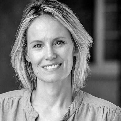Black-and-white headshot of Maureen Flannigan, executive producer and documentary filmmaker, smiling at the camera in a light textured blouse.